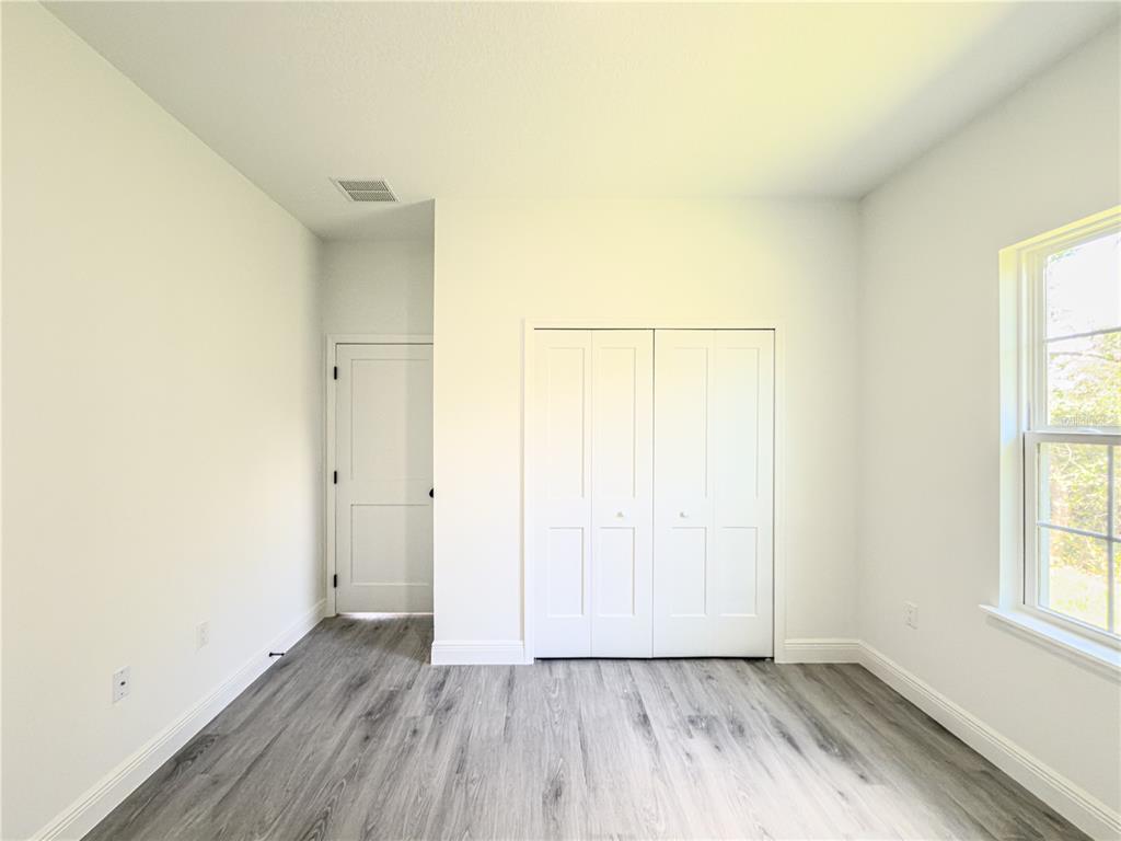 14245 Southwest 28th Court Ocala, FL 34473 - Photo 61 of 85 an empty room with wooden floor and windows