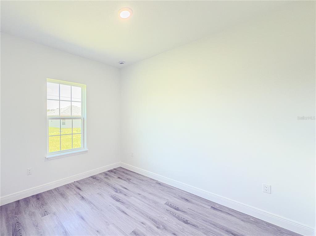 14245 Southwest 28th Court Ocala, FL 34473 - Photo 62 of 85 an empty room with a window and wooden floor