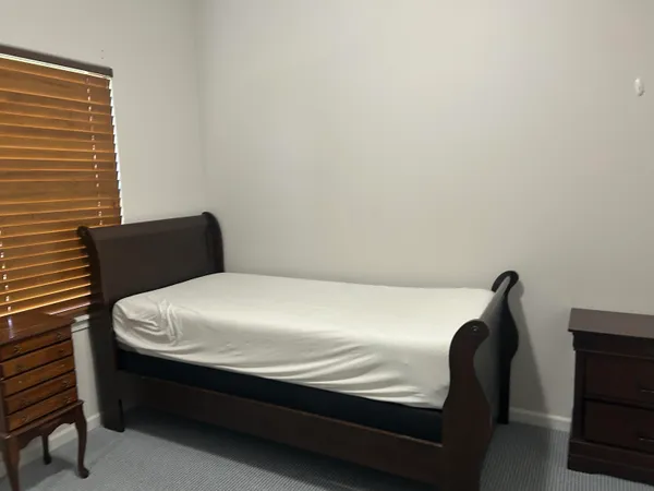 a bed sitting in a bedroom next to a window
