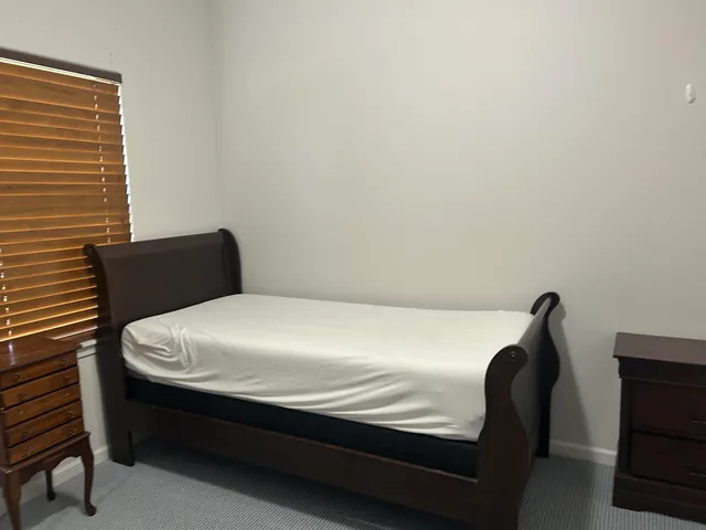 a bed sitting in a bedroom next to a window