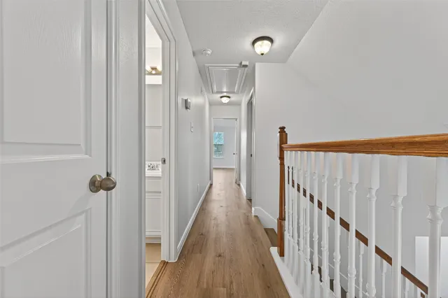 an empty room with wooden floor and a ceiling fan