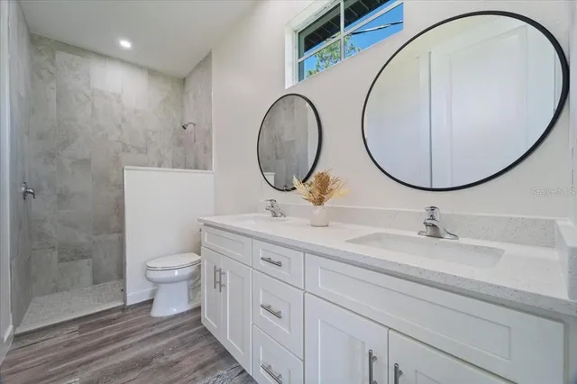 a bathroom with a sink a toilet and a mirror