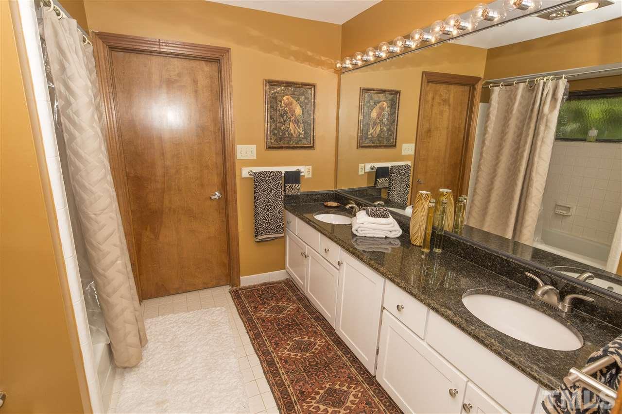 813 Thatcher Way Raleigh, NC 27615 - Photo 17 of 25 a bathroom with a granite countertop double vanity sink a mirror a shower and a bathtub