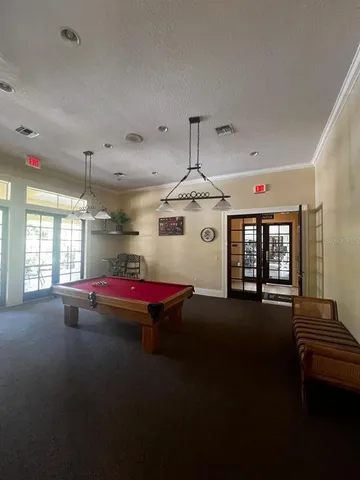 a room with pool table and windows