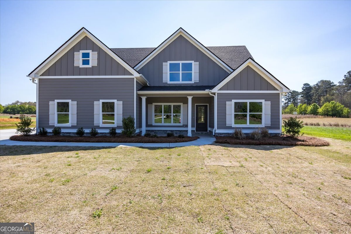 a front view of a house with yard and trees