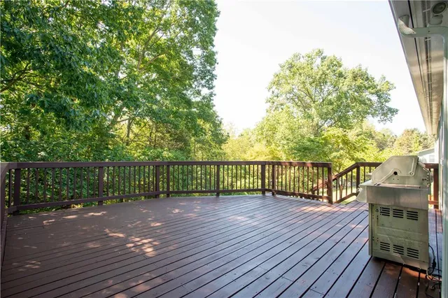 a view of a deck with wooden floor and fence with a large garden