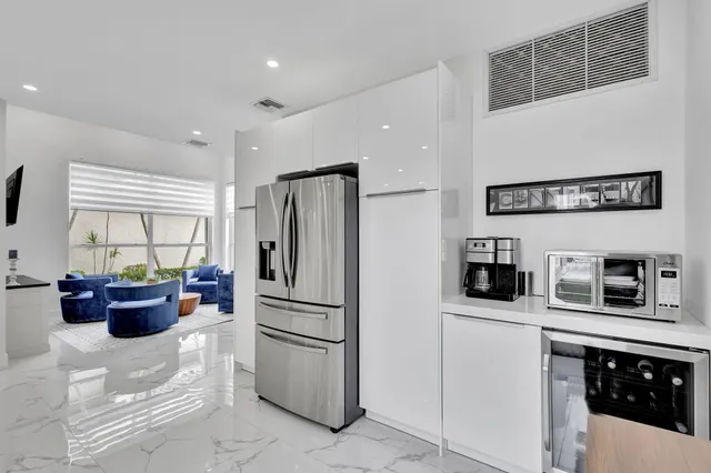 a large white kitchen with a sink and a stove top oven