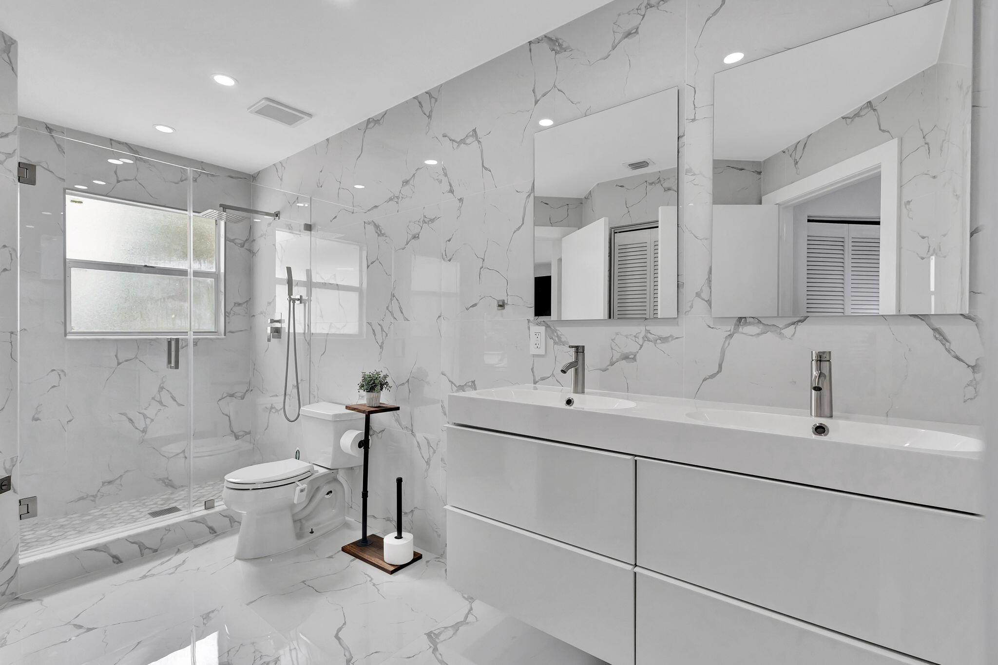 6631 Northwest 25th Avenue Boca Raton, FL 33496 - Photo 32 of 59 a bathroom with a double vanity sink mirror and toilet