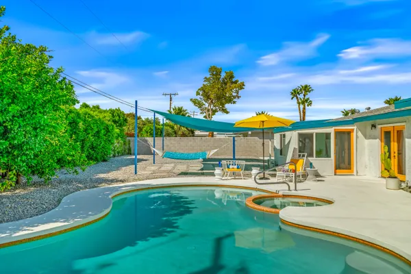 a swimming pool with outdoor seating and yard