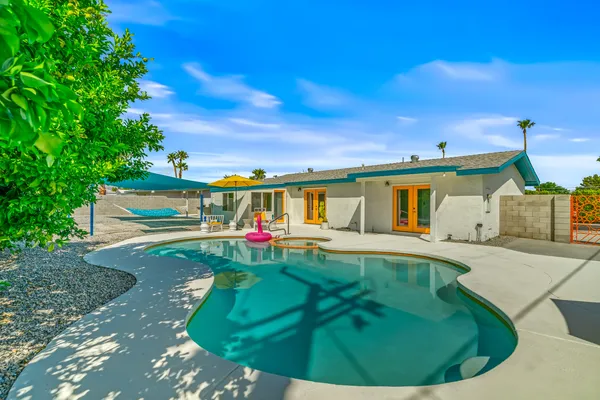 a view of a house with swimming pool and sitting area