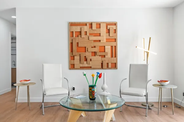 a view of a dining room with furniture a rug and wooden floor