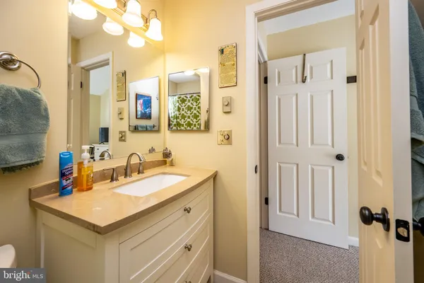 a bathroom with a granite countertop sink and a mirror