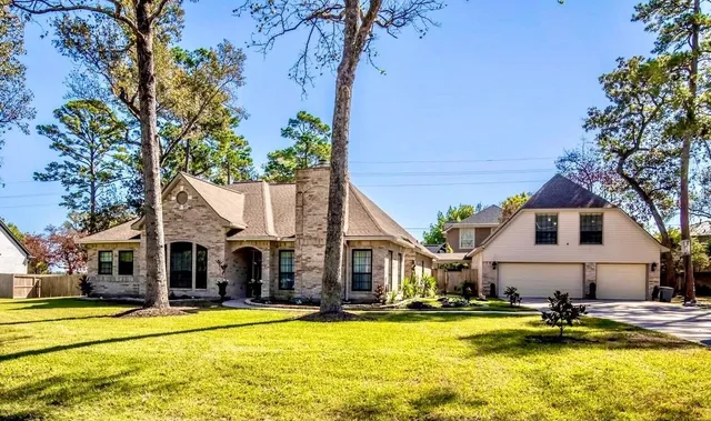 a view of a swimming pool with house and trees in the background