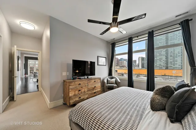a bedroom with a bed flat screen tv and a large window
