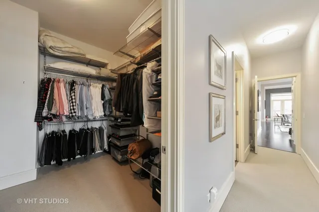 a view of walk in closet with clothes and shoes