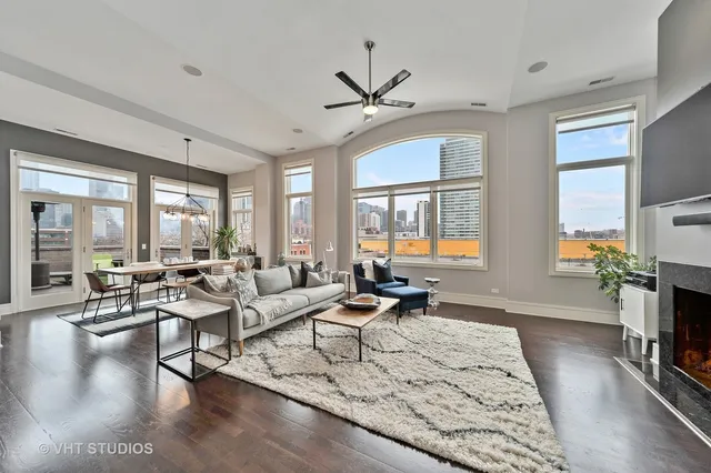 a living room with fireplace furniture and a large window