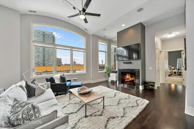 a living room with furniture fireplace and a large window