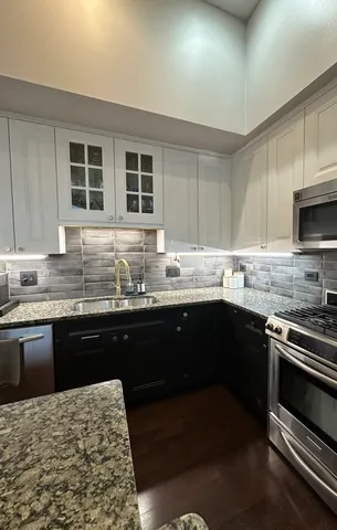 a kitchen with granite countertop stainless steel appliances and wooden cabinets