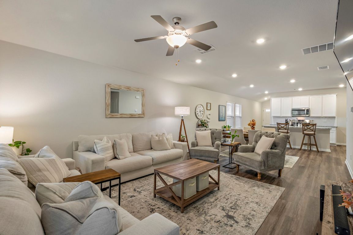 a living room with furniture kitchen view and a chandelier