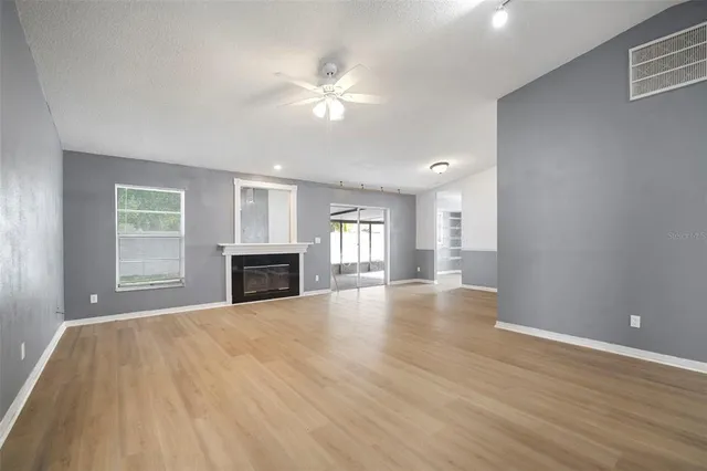 a view of an empty room with a fireplace and a window