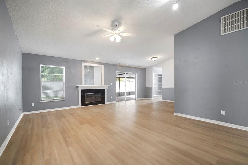 12825 Tallowood Drive Riverview, FL 33579 - Photo 12 of 43 a view of an empty room with wooden floor and a window