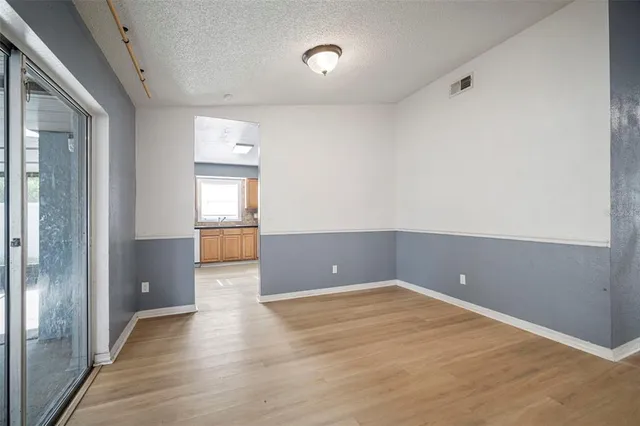 an empty room with wooden floor and sliding door