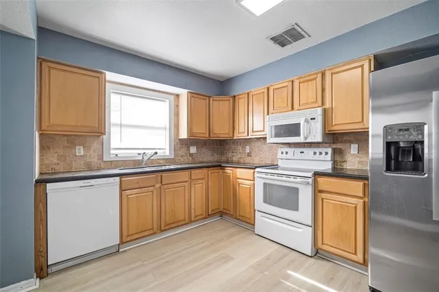 a kitchen with stainless steel appliances granite countertop a refrigerator and a sink