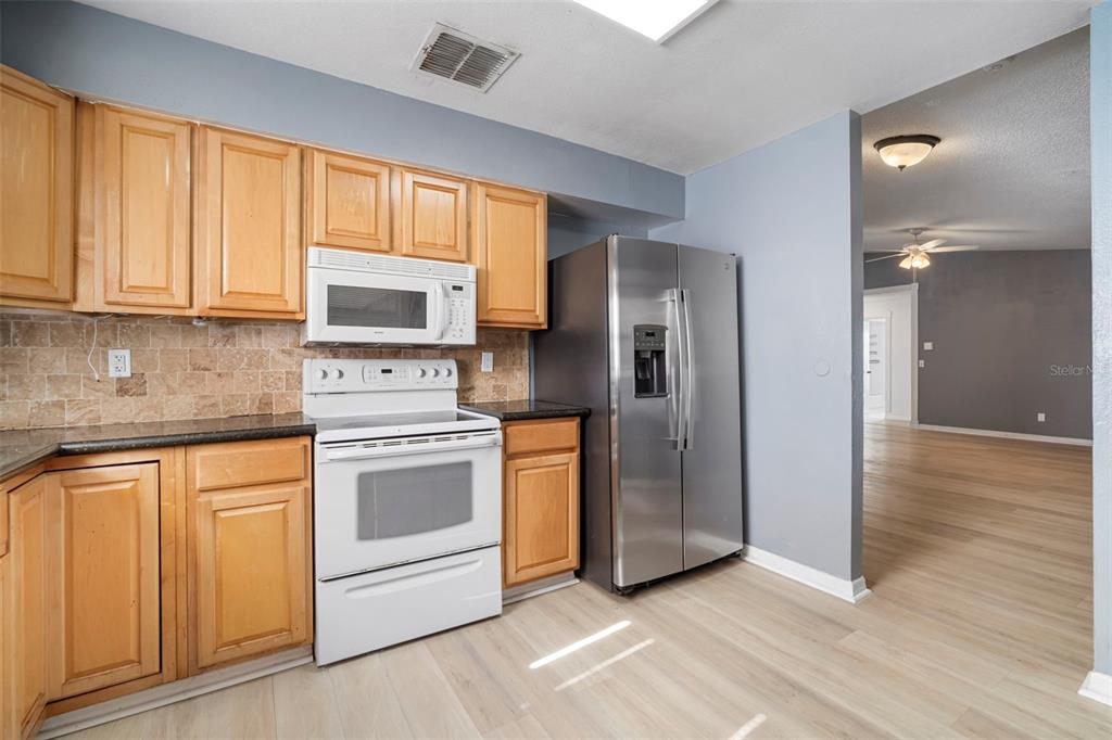 12825 Tallowood Drive Riverview, FL 33579 - Photo 26 of 43 a kitchen with stainless steel appliances granite countertop a refrigerator stove and sink