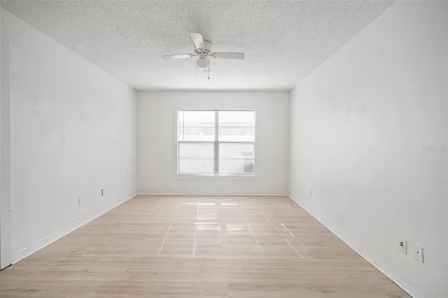 an empty room with windows and cabinet