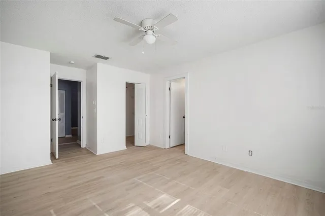 a view of empty room with ceiling fan