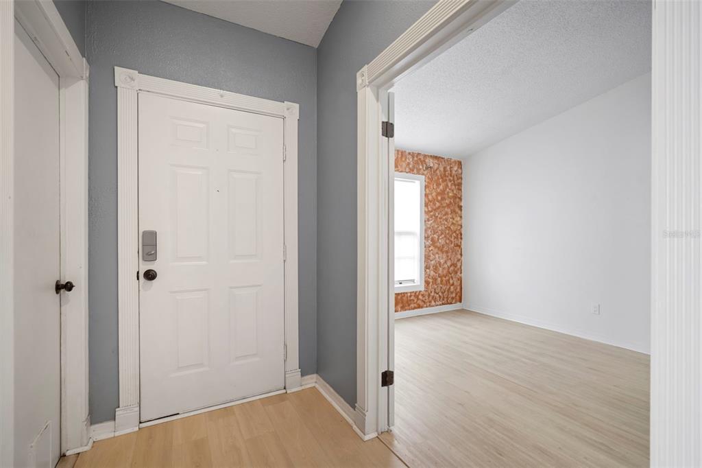 12825 Tallowood Drive Riverview, FL 33579 - Photo 4 of 43 a view of an empty room with wooden floor and a window