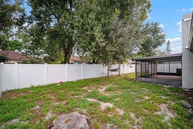 a view of a white house with a big yard and large tree