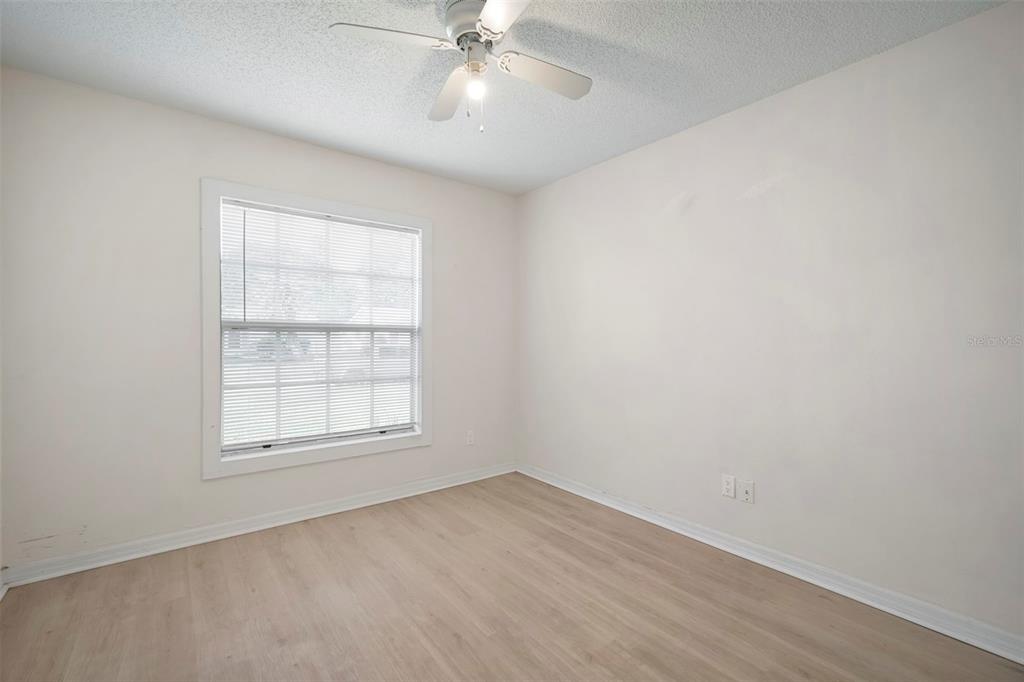 12825 Tallowood Drive Riverview, FL 33579 - Photo 8 of 43 an empty room with chandelier fan and windows