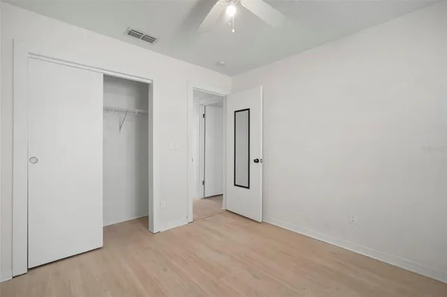 an empty room with a window and a fan