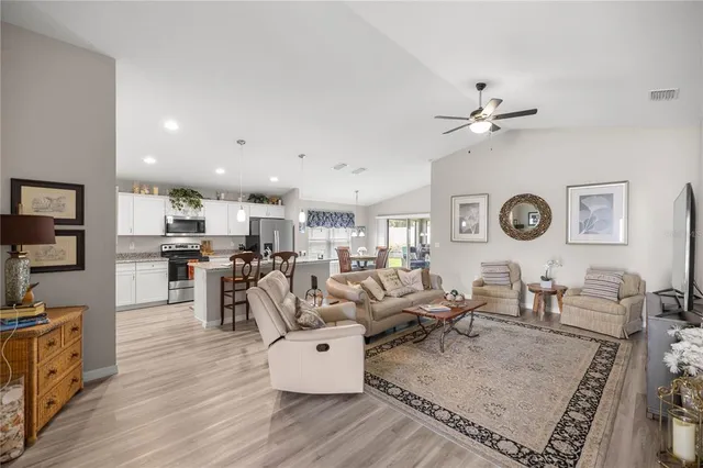 a living room with lots of furniture and view of kitchen