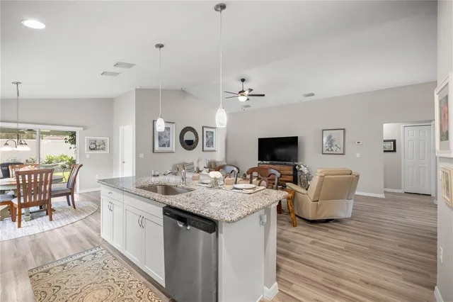 a living room with granite countertop furniture a flat screen tv and kitchen view