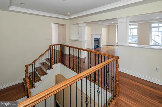 a view of staircase with wooden floor and white walls