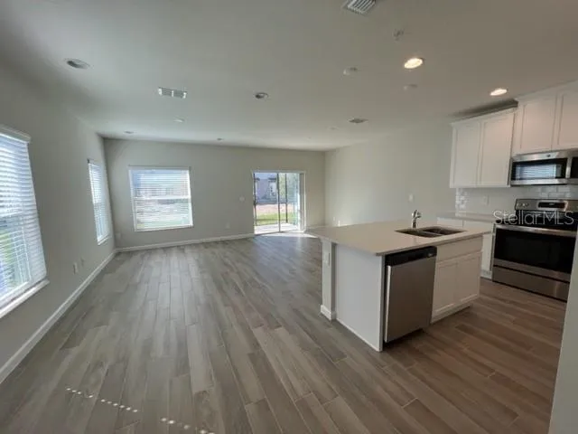 a kitchen with cabinets wooden floor and a sink