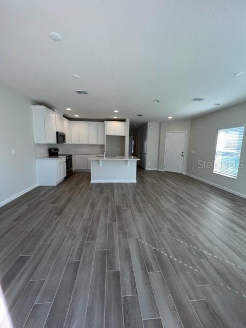 2327 Prickly Pear Way Sanford, FL 32771 - Photo 6 of 33 a view of a big room with wooden floor and windows