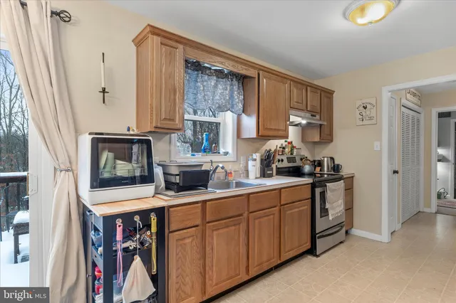 a kitchen with stainless steel appliances a stove microwave and sink