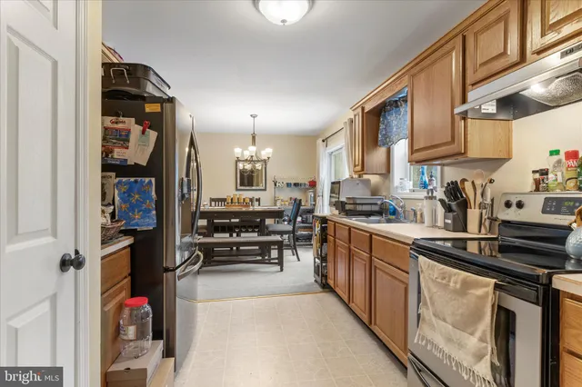 a kitchen with stainless steel appliances granite countertop a refrigerator and a stove top oven
