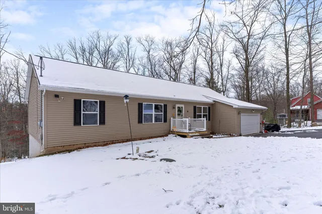 a front view of a house with a yard covered in snow