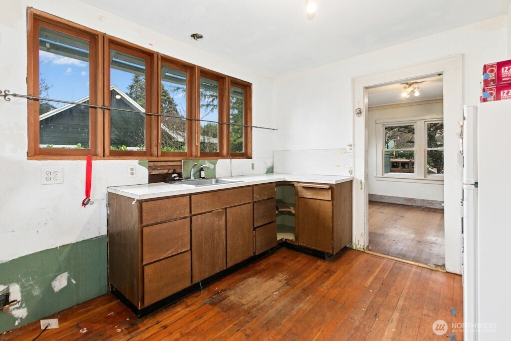5627 44th Avenue Southwest Seattle, WA 98136 - Photo 13 of 37 a kitchen with a sink window and cabinets