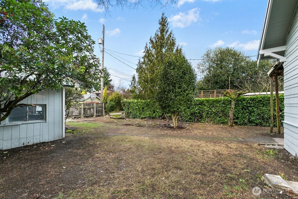 5627 44th Avenue Southwest Seattle, WA 98136 - Photo 24 of 37 a view of a house with a tree and a yard