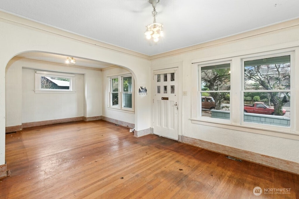 5627 44th Avenue Southwest Seattle, WA 98136 - Photo 7 of 37 a view of an empty room with a window and wooden floor
