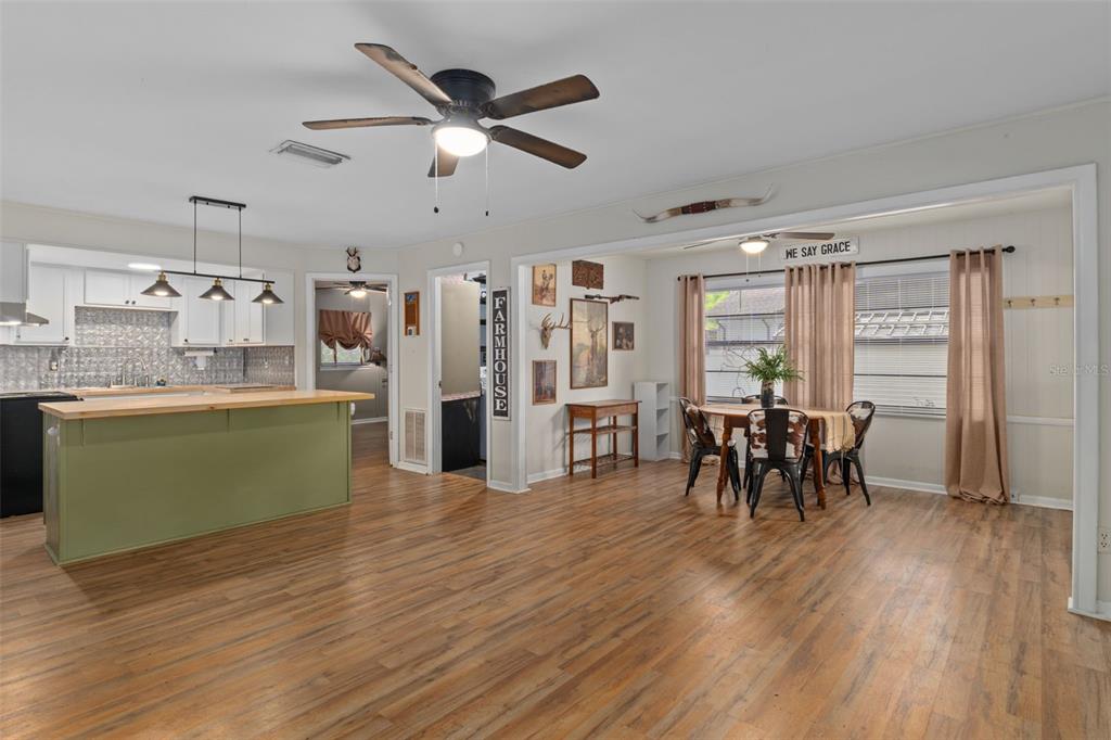 353 North Robin Hood Road Inverness, FL 34450 - Photo 11 of 59 a dining room with furniture a floor to ceiling window and wooden floor