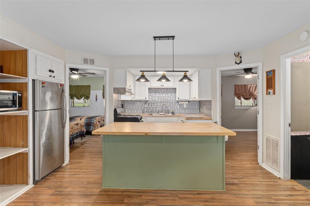 353 North Robin Hood Road Inverness, FL 34450 - Photo 15 of 59 a large kitchen with kitchen island stainless steel appliances and wooden floor