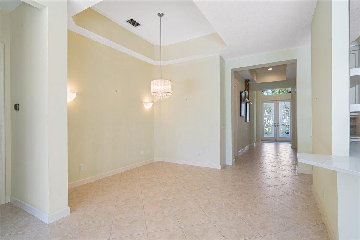 8332 Muirfield Way Port St. Lucie, FL 34986 - Photo 18 of 55 a view of a hallway with wooden floor and chandelier