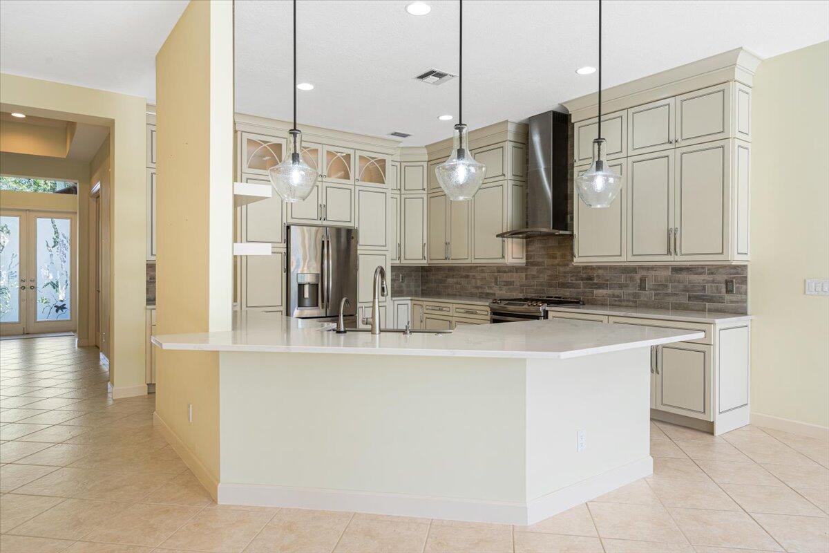 8332 Muirfield Way Port St. Lucie, FL 34986 - Photo 30 of 55 a kitchen with stainless steel appliances granite countertop a sink a refrigerator and a wooden floor