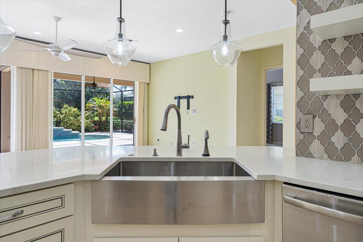8332 Muirfield Way Port St. Lucie, FL 34986 - Photo 32 of 55 a kitchen with a sink a counter top space and a chandelier